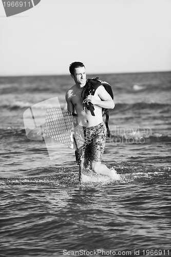 Image of Portrait of a young  kitsurf  man at beach on sunset