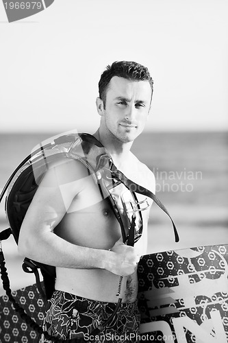 Image of Portrait of a young  kitsurf  man at beach on sunset