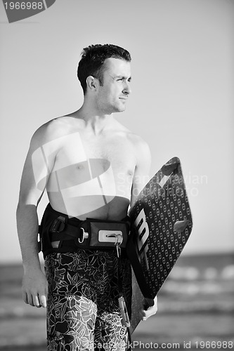 Image of Portrait of a young  kitsurf  man at beach on sunset