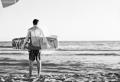 Image of Portrait of a young  kitsurf  man at beach on sunset