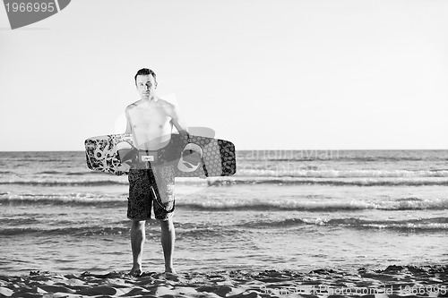 Image of Portrait of a young  kitsurf  man at beach on sunset