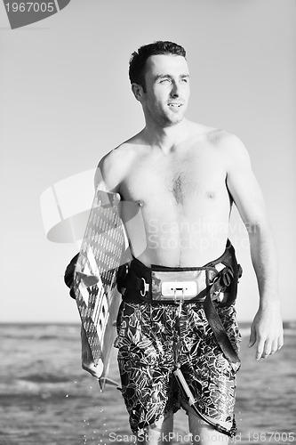 Image of Portrait of a young  kitsurf  man at beach on sunset