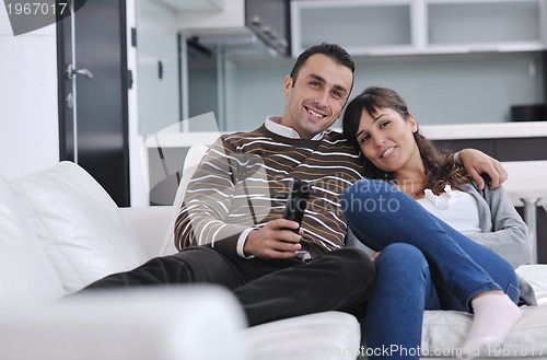 Image of Relaxed young  couple watching tv at home
