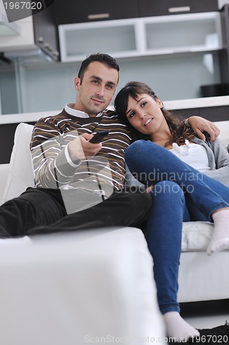 Image of Relaxed young  couple watching tv at home