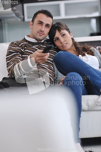 Image of Relaxed young  couple watching tv at home