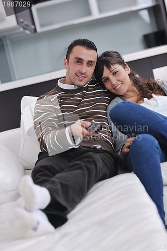 Image of Relaxed young  couple watching tv at home