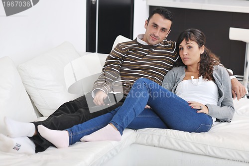 Image of Relaxed young  couple watching tv at home