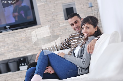 Image of Relaxed young  couple watching tv at home