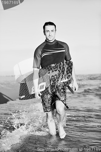 Image of Portrait of a young  kitsurf  man at beach on sunset