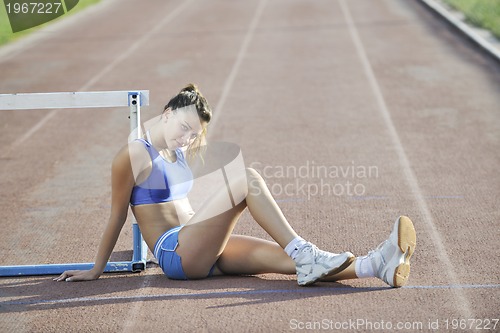 Image of happy young woman on athletic race track