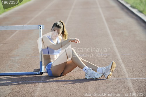 Image of happy young woman on athletic race track
