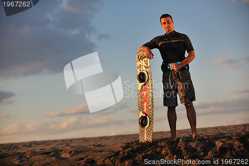 Image of Portrait of a young  kitsurf  man at beach on sunset