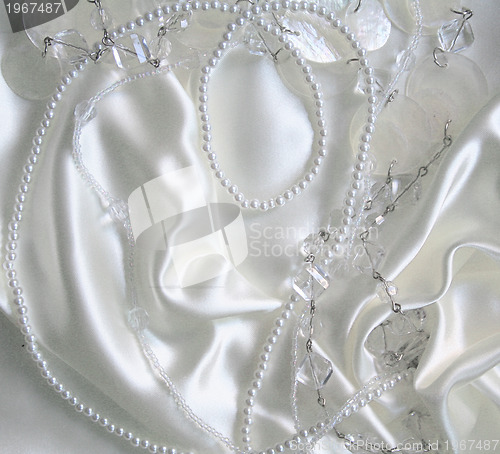 Image of White pearls and nacreous beeds on white silk 