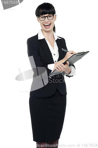 Image of Charming businesswoman writing on notepad