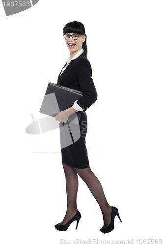 Image of Cheerful smart business lady walking with files