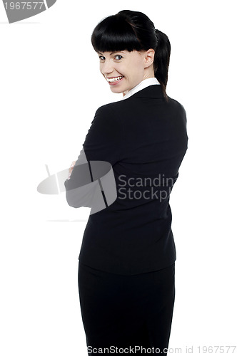 Image of Young corporate lady turning back and smiling