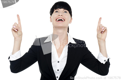 Image of Excited businesswoman looking ad pointing upwards