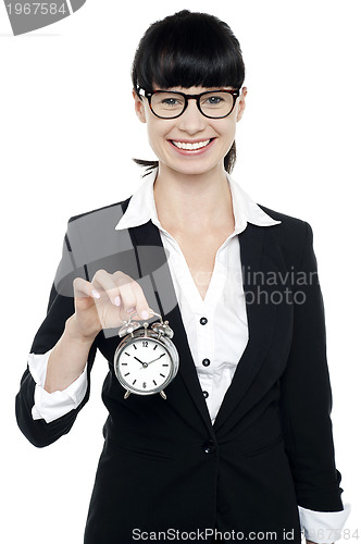 Image of Smiling young lady holding old fashioned time piece