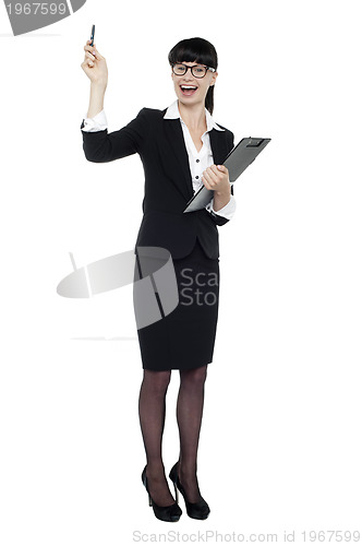 Image of Cheerful businesswoman posing with raised arm