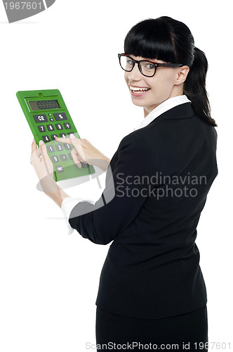 Image of Bespectacled woman turning back, holding calculator