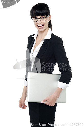 Image of Cheerful office employee holding laptop