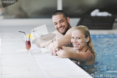 Image of happy cople relaxing  at swimming pool