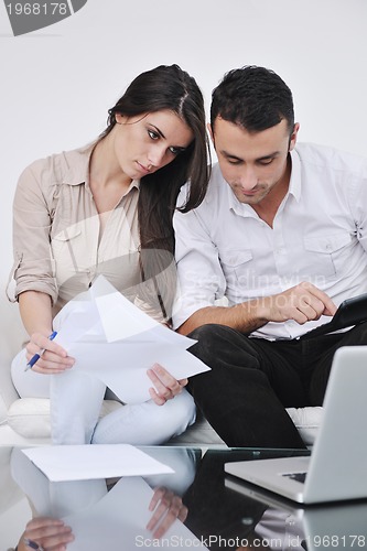 Image of joyful couple relax and work on laptop computer at modern home