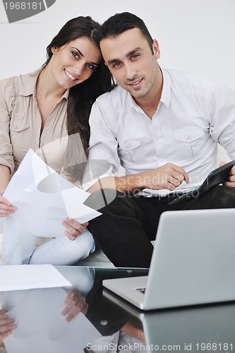 Image of joyful couple relax and work on laptop computer at modern home
