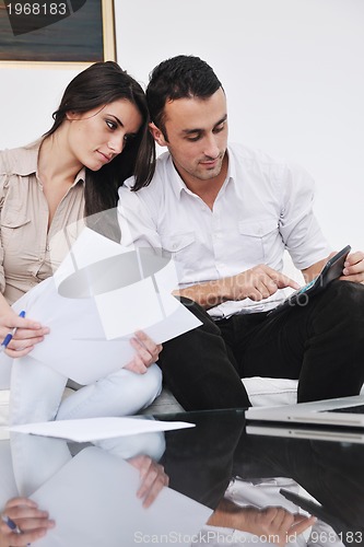 Image of joyful couple relax and work on laptop computer at modern home