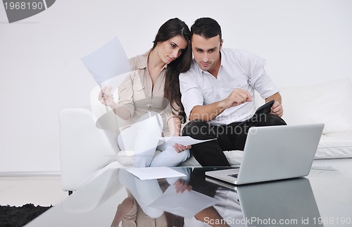 Image of joyful couple relax and work on laptop computer at modern home