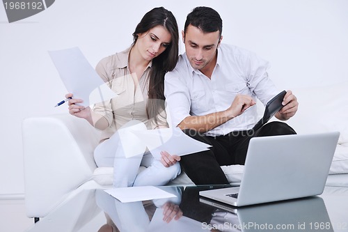 Image of joyful couple relax and work on laptop computer at modern home