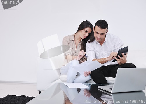 Image of joyful couple relax and work on laptop computer at modern home