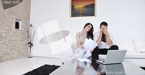 Image of joyful couple relax and work on laptop computer at modern home