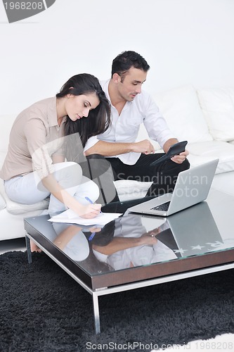 Image of joyful couple relax and work on laptop computer at modern home