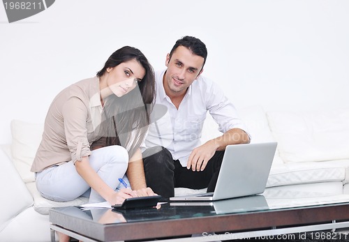 Image of joyful couple relax and work on laptop computer at modern home