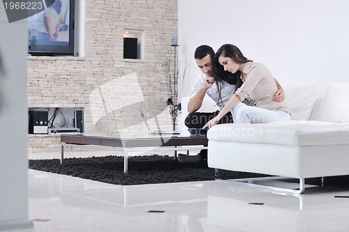 Image of joyful couple relax and work on laptop computer at modern home