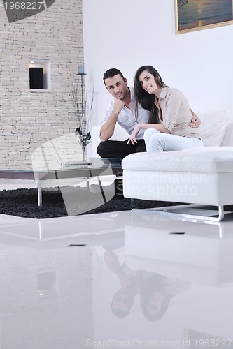 Image of joyful couple relax and work on laptop computer at modern home