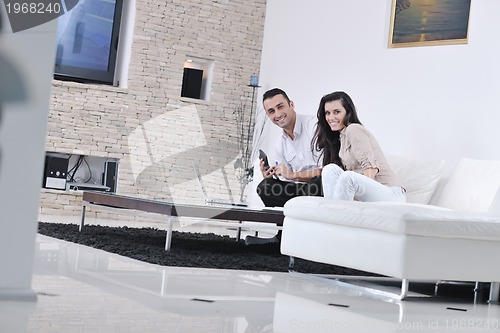 Image of joyful couple relax and work on laptop computer at modern home