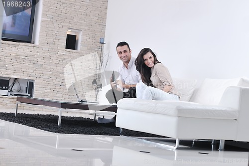 Image of joyful couple relax and work on laptop computer at modern home