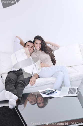 Image of joyful couple relax and work on laptop computer at modern home