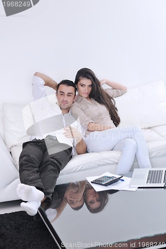 Image of joyful couple relax and work on laptop computer at modern home