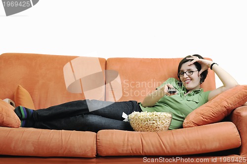 Image of young woman eat popcorn on orange sofa
