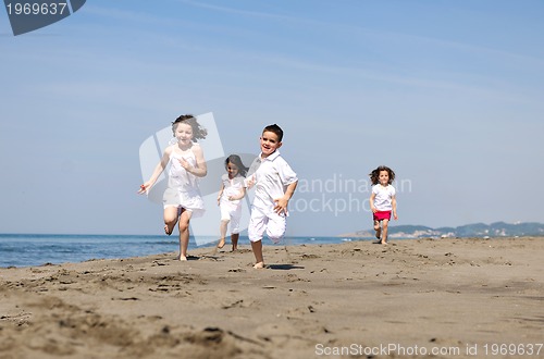 Image of happy child group playing  on beach
