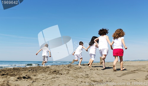 Image of happy child group playing  on beach