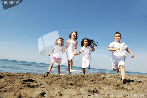 Image of happy child group playing  on beach