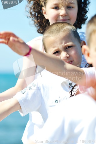 Image of happy child group playing  on beach
