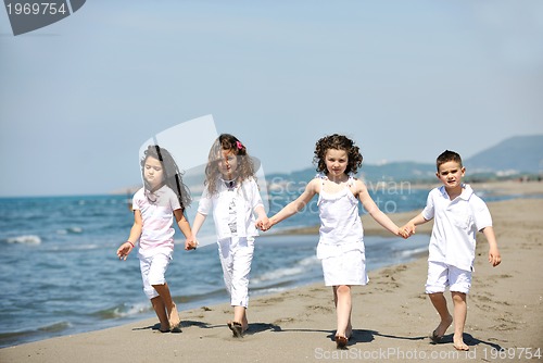 Image of happy child group playing  on beach