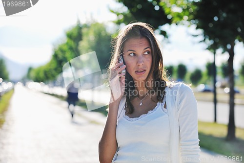 Image of young woman talk by cellphone on street