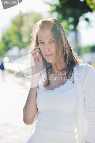 Image of young woman talk by cellphone on street