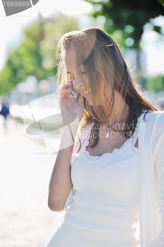 Image of young woman talk by cellphone on street